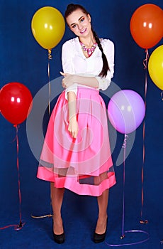 Portrait of a young attractive woman near many bright balloons