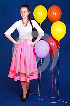 Portrait of a young attractive woman near many bright balloons