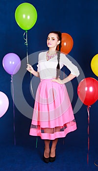 Portrait of a young attractive woman near many bright balloons