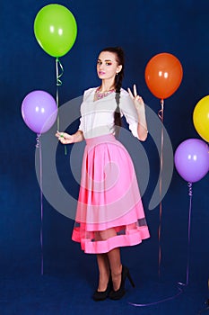 Portrait of a young attractive woman near many bright balloons