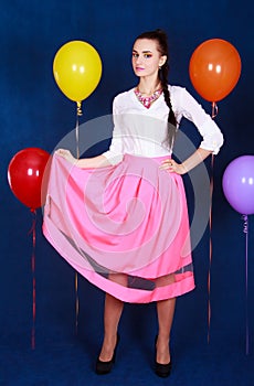 Portrait of a young attractive woman near many bright balloons