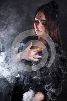 Portrait of a young attractive woman in a puff of smoke