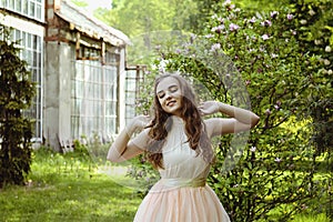 Portrait of young attractive woman walking in spring garden in sunny day. Spring background. Woman's Day