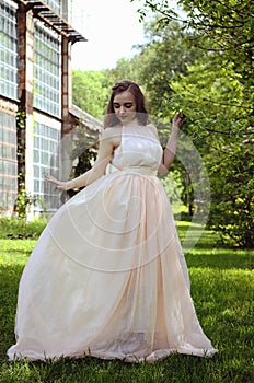 Portrait of young attractive woman walking in spring garden in sunny day. Spring background. Woman's Day