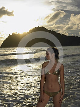 Portrait of young attractive woman wearing bikini while posing on the beach