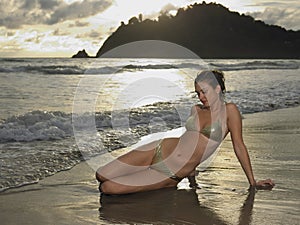 Portrait of young attractive woman wearing bikini while posing on the beach