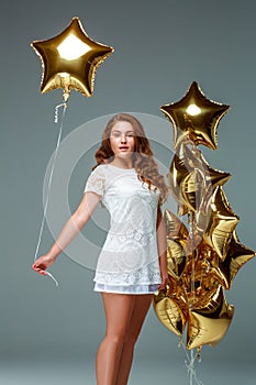 Portrait young attractive woman in white dress, holding bunch of