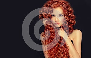 Portrait of young, attractive young model with incredible dense, long, curly red hair.Frizzy hair.