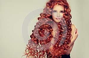 Portrait of young, attractive young model with incredible dense, long, curly red hair.Frizzy hair.