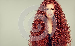 Portrait of young, attractive young model with incredible dense, long, curly red hair.Frizzy hair.