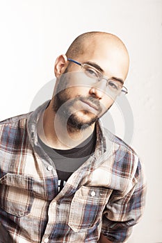 Portrait of a young bald man with a beard and glasses