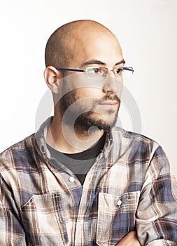 Portrait of a young bald man with a beard and glasses