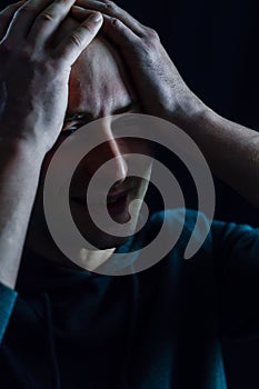 Portrait of a young bald man who with his hands on his head looks desperate