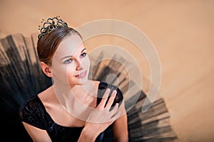 Portrait of a young ballerina in black tutu and crown