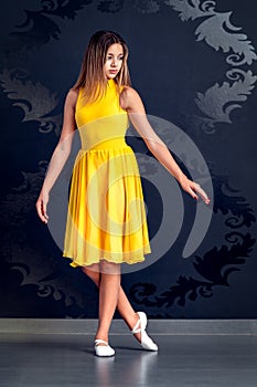 portrait of a young ballerina girl in yellow ballet dress