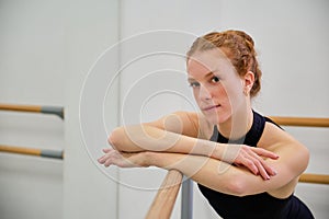 Portrait of a young ballerina looking at camera in a ballet school.