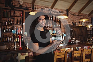 Portrait of young barman writing on diary
