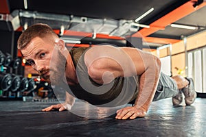 Portrait of young bearded athletic man doing push-ups in the gym. Close-up. The concept of fitness and training