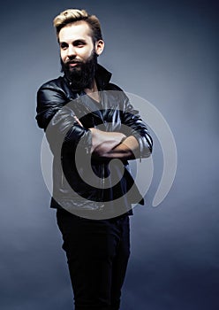 Portrait of young bearded hipster guy on gray dark background cl