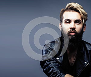 Portrait of young bearded hipster guy on gray dark background cl