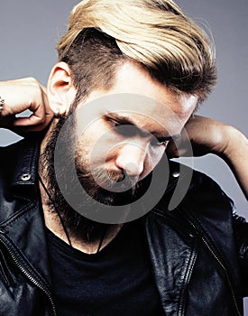 Portrait of young bearded hipster guy on gray dark background close up, brutal modern man, lifestyle people concept