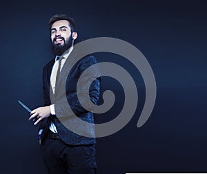 portrait of young bearded hipster guy on gray dark background close up, brutal modern man in suit, lifestyle people