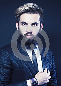 portrait of young bearded hipster guy on gray dark background close up, brutal modern man in suit, lifestyle people