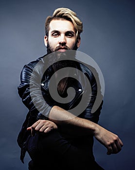 Portrait of young bearded hipster guy smiling on gray dark background close up, brutal modern man, lifestyle people