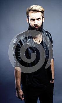 Portrait of young bearded hipster guy smiling on gray dark background close up, brutal modern man, lifestyle people