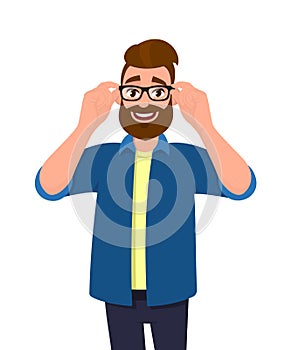 Portrait of young bearded man holding or adjusting the eye glasses with hands. Trendy person wearing spectacles. Male character.