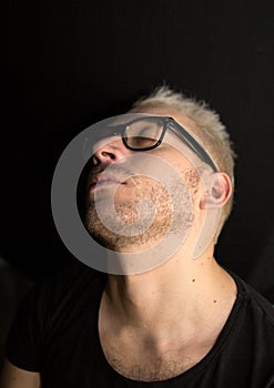 A portrait of a young bearded man. A portrait of a man with black glasses. A man with closed eyes.