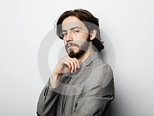 Portrait of young bearded man posing over white background, casual style