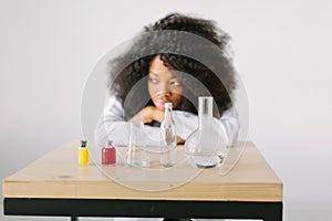 Portrait of a young beautiful African American girl researcher chemistry student carrying out research in a chemistry