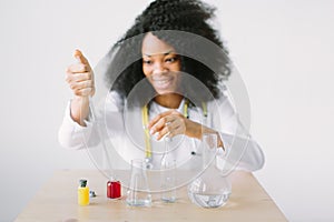 Portrait of a young beautiful African American girl researcher chemistry student carrying out research in a chemistry