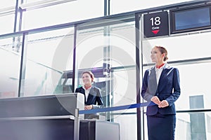 Portrait of young beautiful airport staff opening the gate for boarding in airport photo