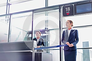 Portrait of young beautiful airport staff opening the gate for boarding in airport