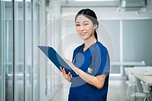 Young woman doctor checking reports in hospital