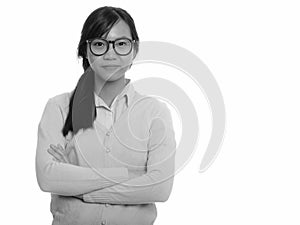 Portrait of young beautiful Asian teenage girl wearing eyeglasses with arms crossed