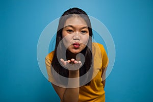 Portrait of Young beautiful asian women wearing yellow shirt with blue isolated background