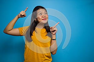 Portrait of Young beautiful asian women wearing yellow shirt with blue isolated background