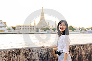 Portrait young beautiful asian woman smiling while travel at Wat Arun sunset view point, Bangkok, Thailand