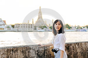 Portrait young beautiful asian woman smiling while travel at Wat Arun sunset view point, Bangkok, Thailand