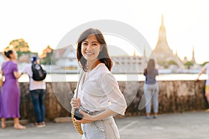 Portrait young beautiful asian woman smiling while travel at Wat Arun sunset view point, Bangkok, Thailand