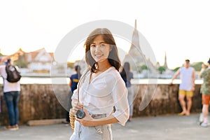 Portrait young beautiful asian woman smiling while travel at Wat Arun sunset view point, Bangkok, Thailand