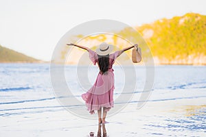 Portrait young beautiful asian woman walk smile and happy on the beach sea and ocean