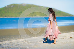 Portrait young beautiful asian woman walk smile and happy on the beach sea and ocean