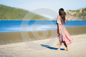 Portrait young beautiful asian woman walk smile and happy on the beach sea and ocean