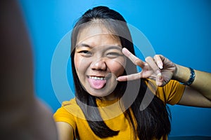 Portrait of Young beautiful asian women wearing yellow shirt with blue isolated background