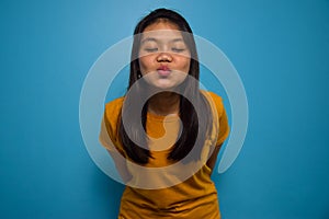 Portrait of Young beautiful asian women wearing yellow shirt with blue isolated background