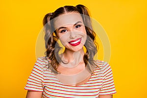 Portrait of young beautiful attractive pretty smiling cheerful good mood girl with two pigtails isolated on yellow color